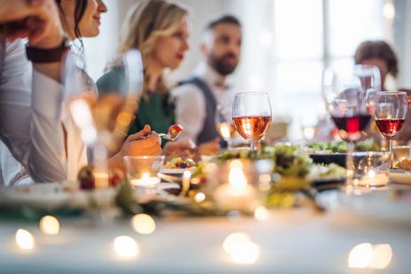 Een grote familie zittend aan een tafel op een indoor verjaardagsfeestje, eten